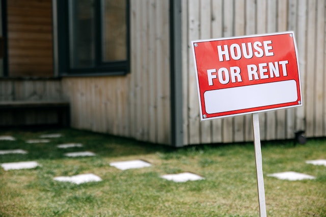 house for rent sign in a front yard